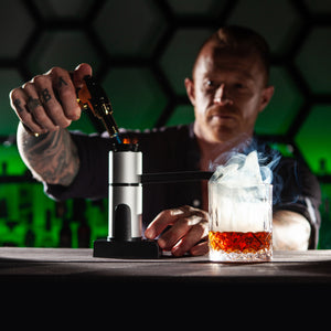 Sixpence Alchemy Cocktail and food smoke infuser kit and barman smoking a Negroni Cocktail